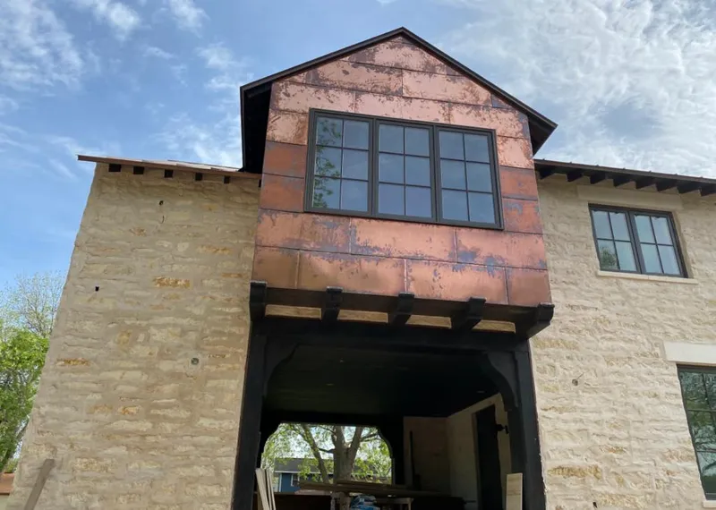Copper metal panel facade on a stone building for Roof Repair in Layton